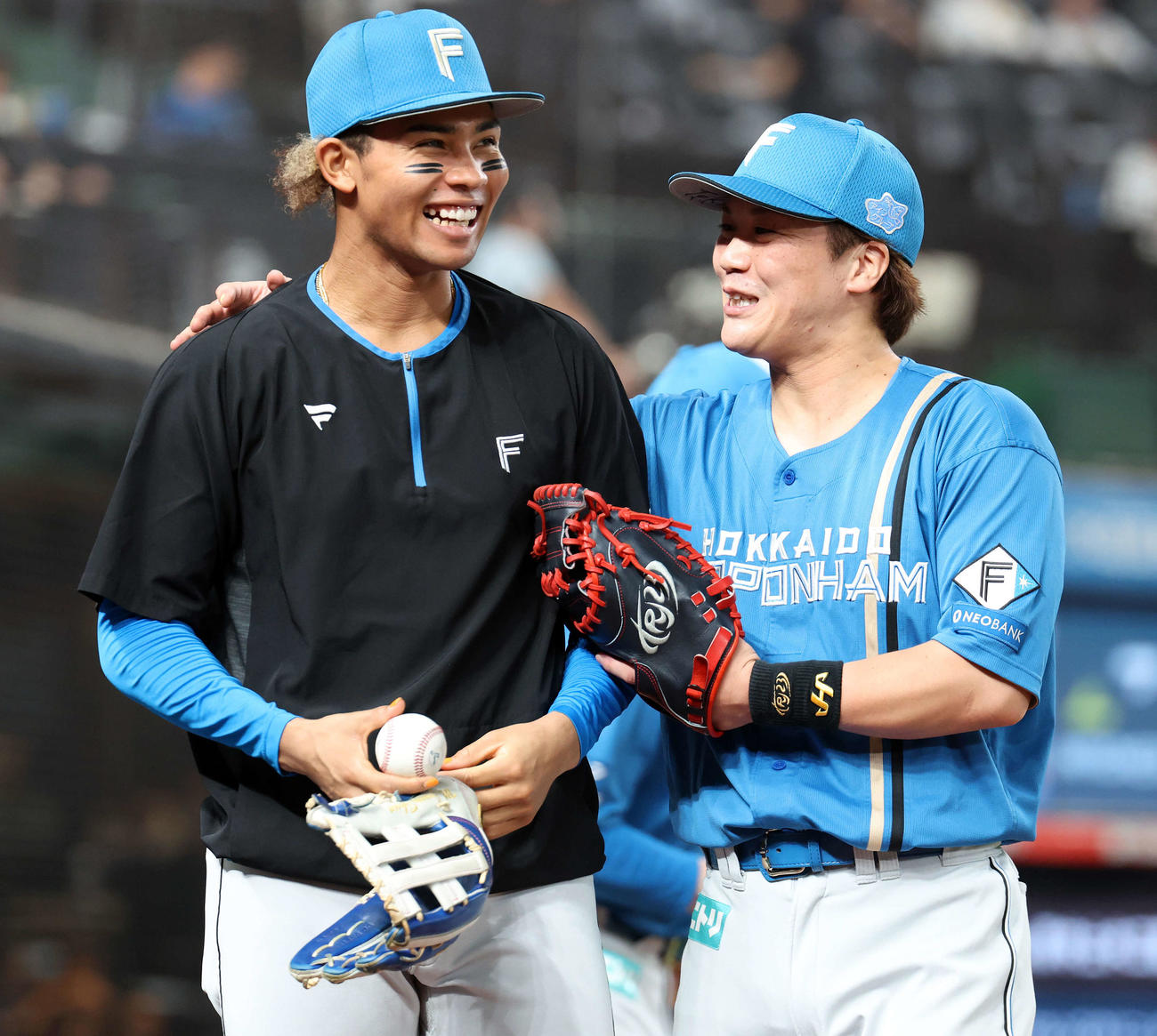西武対日本ハム　イニングの合間に笑顔を見せる日本ハム水谷（左）と伏見（撮影・浅見桂子）