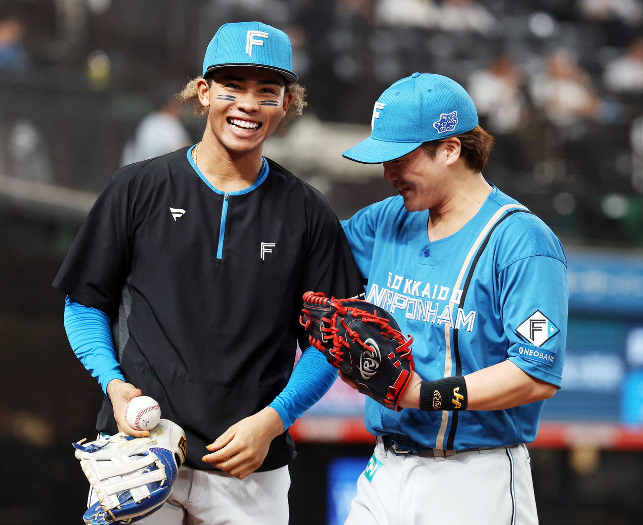 西武対日本ハム　イニングの合間に笑顔を見せる日本ハム水谷（左）と伏見（撮影・浅見桂子）