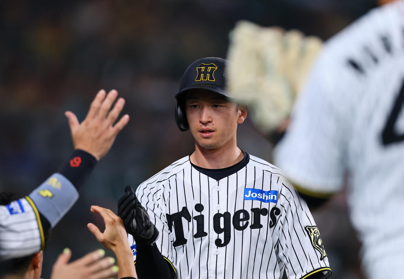 阪神対中日　1回裏阪神2死二塁、佐藤輝の先制適時打で生還し、ナインとタッチを交わす近本（撮影・藤尾明華）