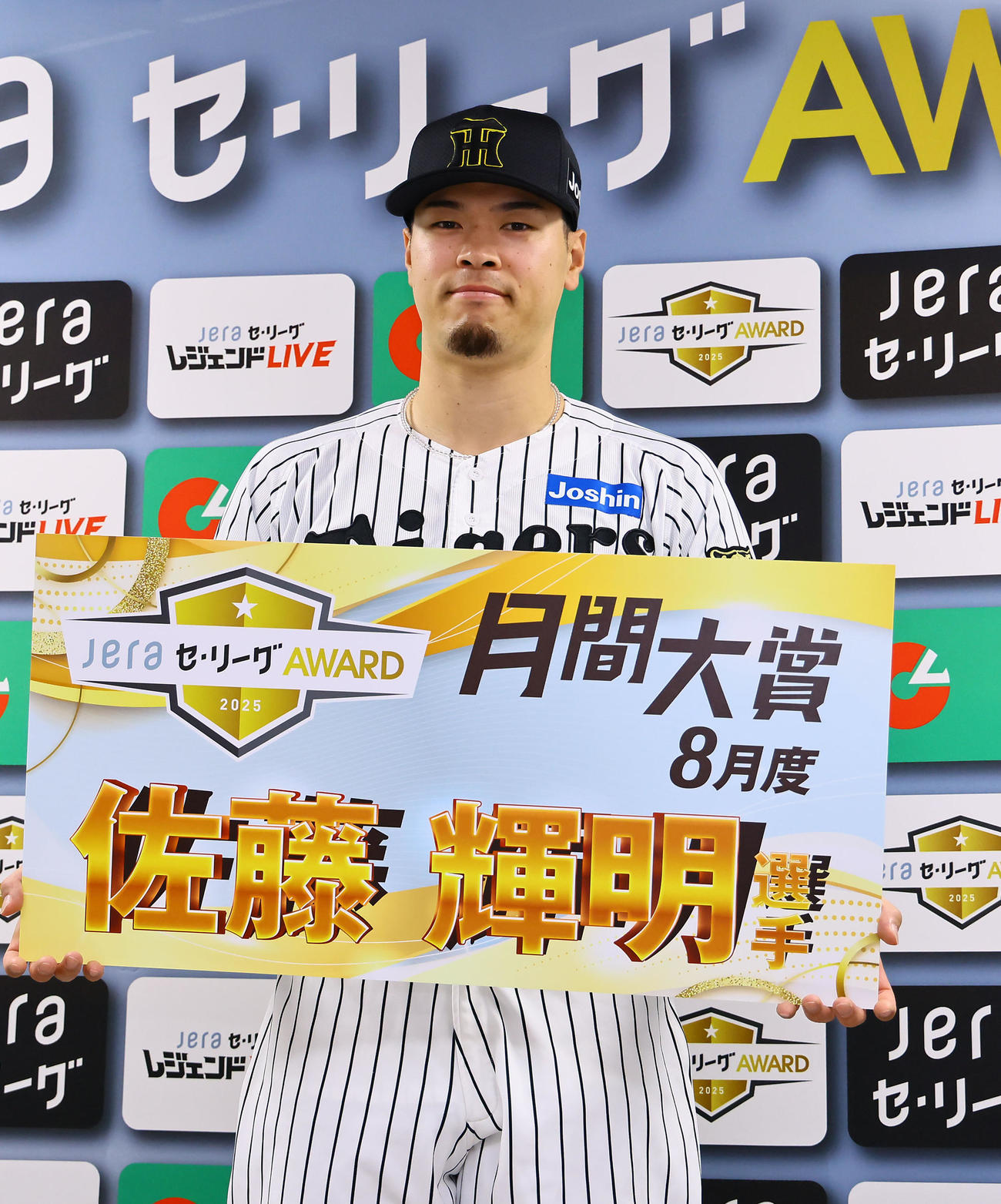 「JERAセ・リーグAWARD8月度月間大賞」を受賞し、記念ボード手に写真に納まる阪神佐藤輝（撮影・藤尾明華）