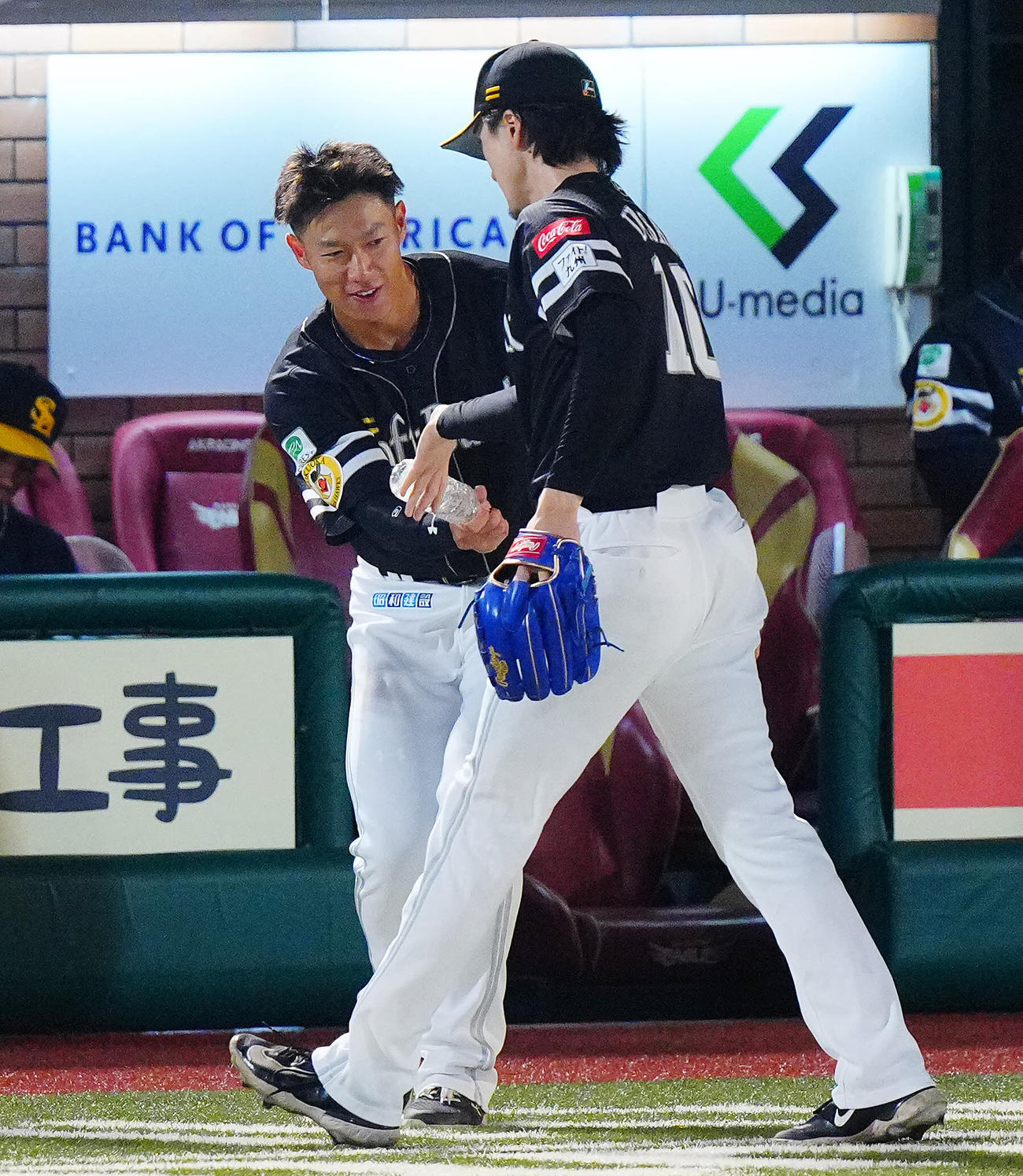 楽天対ソフトバンク　3回裏の登板を終えたソフトバンク先発の上沢（右）にペットボトルを突き出し出迎える柳田（撮影・垰建太）