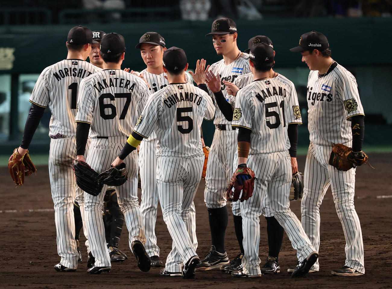 阪神対中日　48イニング無失点の球団記録を達成した石井（左から3人目）はナインとハイタッチして喜ぶ（撮影・上田博志）
