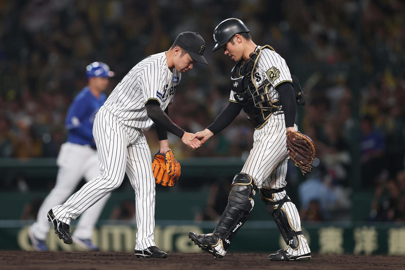 阪神対中日　中日に勝利し、握手を交わす阪神石井（左）と坂本（撮影・前田充）