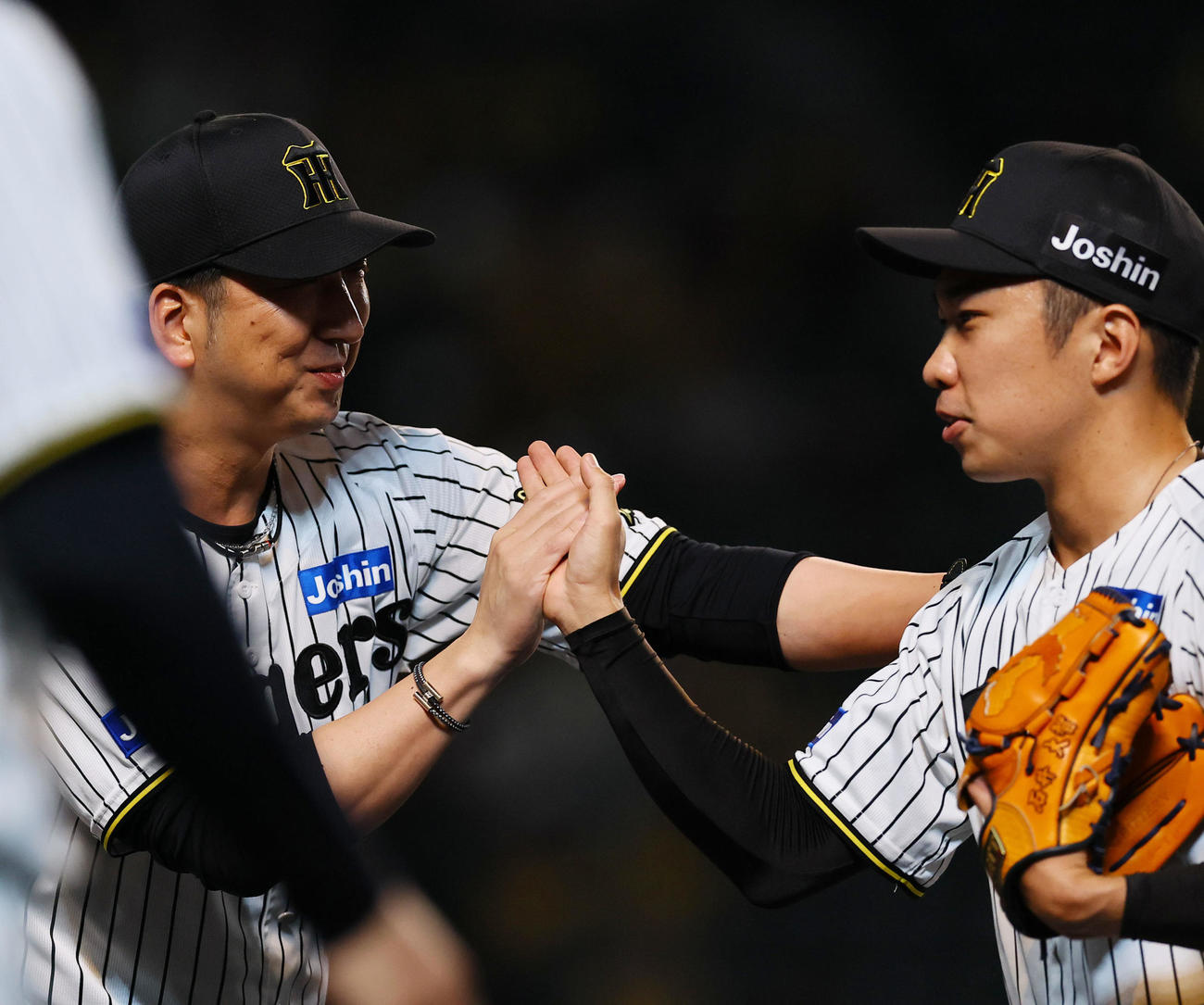 阪神対中日　9回を抑えた石井とタッチを交わす阪神藤川監督（左）（撮影・藤尾明華）