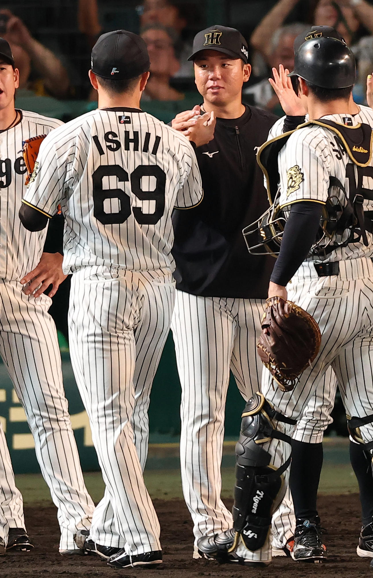 阪神対中日　13勝目を上げた村上（中央）は石井から勝利球を受け取る（撮影・上田博志）
