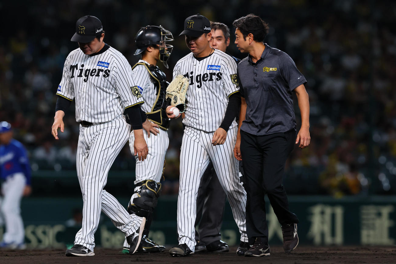 阪神対中日　3回表中日2死、岡林の打球を右足に受け、治療に向かう村上（右から2人目）（撮影・藤尾明華）