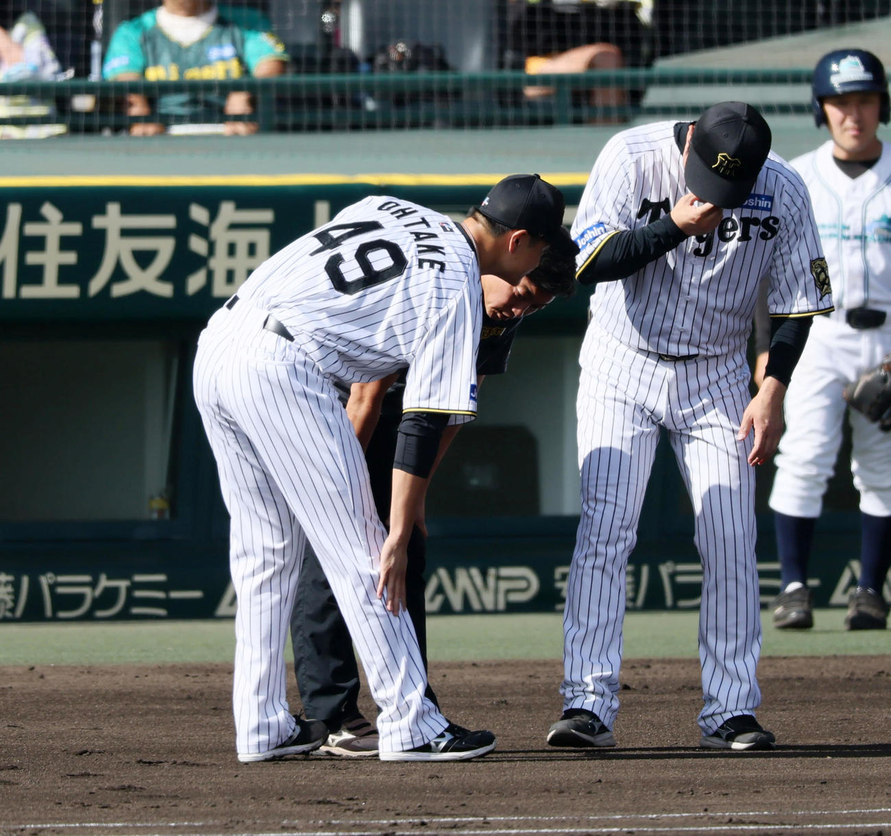阪神対中日　2回表中日1死、大竹は福永の打球を足に受け、患部を触りながら安藤コーチ（右）と話す（撮影・加藤哉）