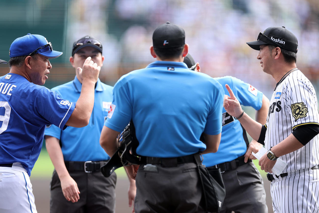 阪神対中日　試合前、メンバー表を交換する中日井上監督（左）と阪神藤川監督（撮影・前田充）