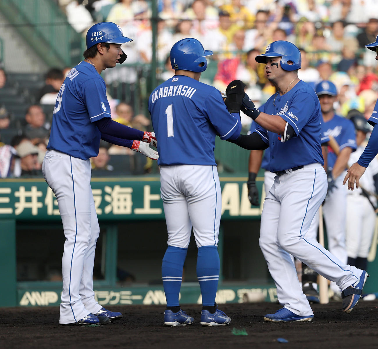 阪神対中日　6回表中日1死一、二塁、3点本塁打を放った細川（右）は高橋宏（左）、岡林の出迎えを受ける（撮影・上田博志）
