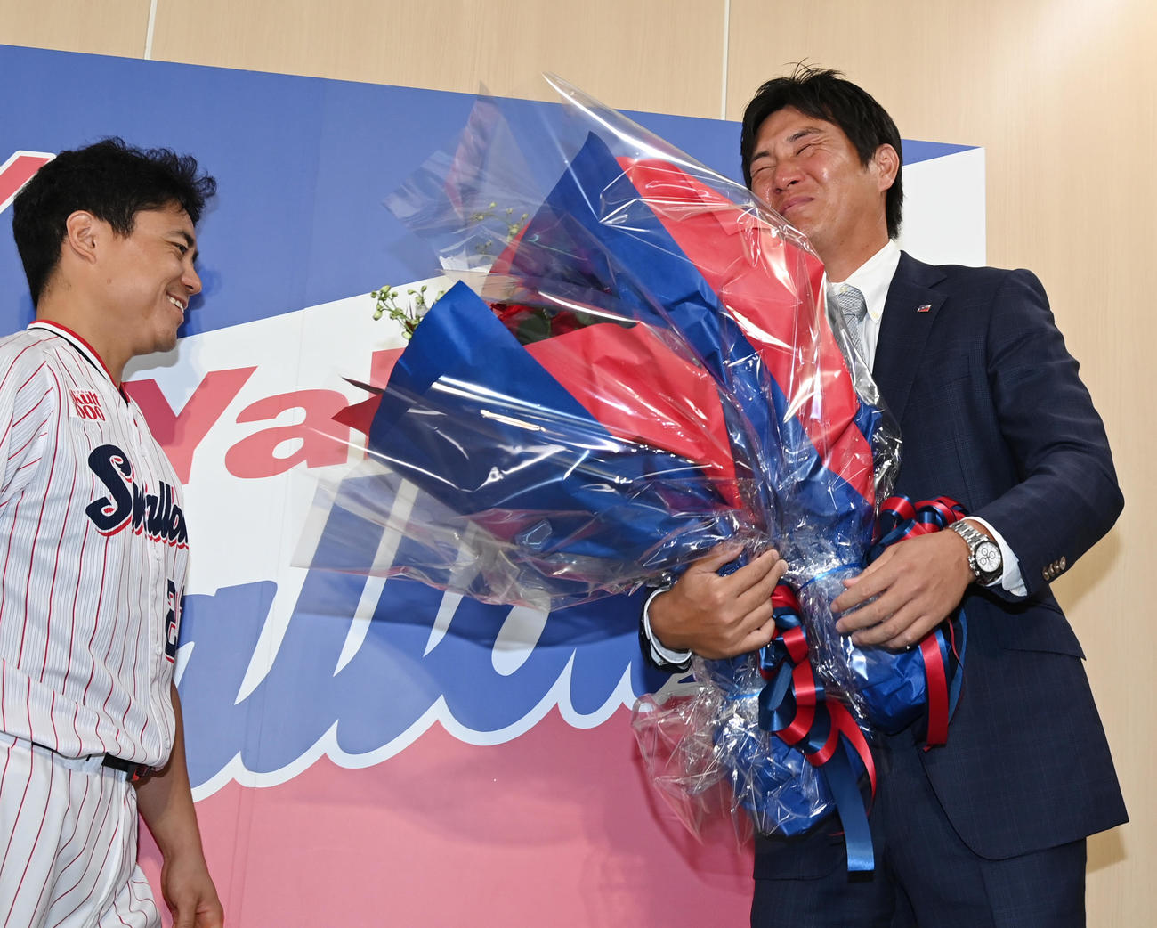会見でヤクルト中村悠（左）らチームメートからの花束に涙をみせる川端（撮影・清水貴仁）