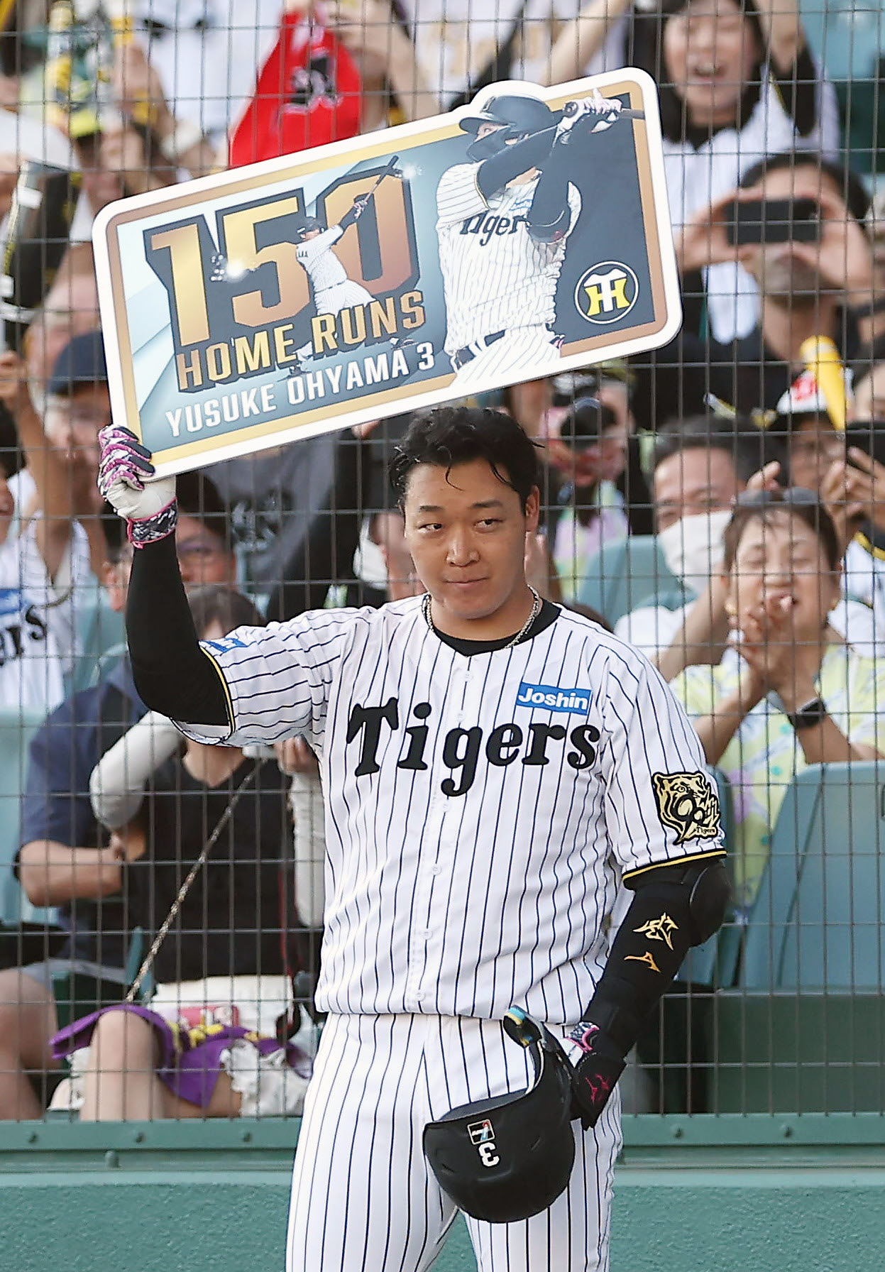 阪神対中日　7回裏阪神2死一、二塁、通算150号となる右越え3点本塁打を放ち、記念ボードを掲げる大山（撮影・前田充）
