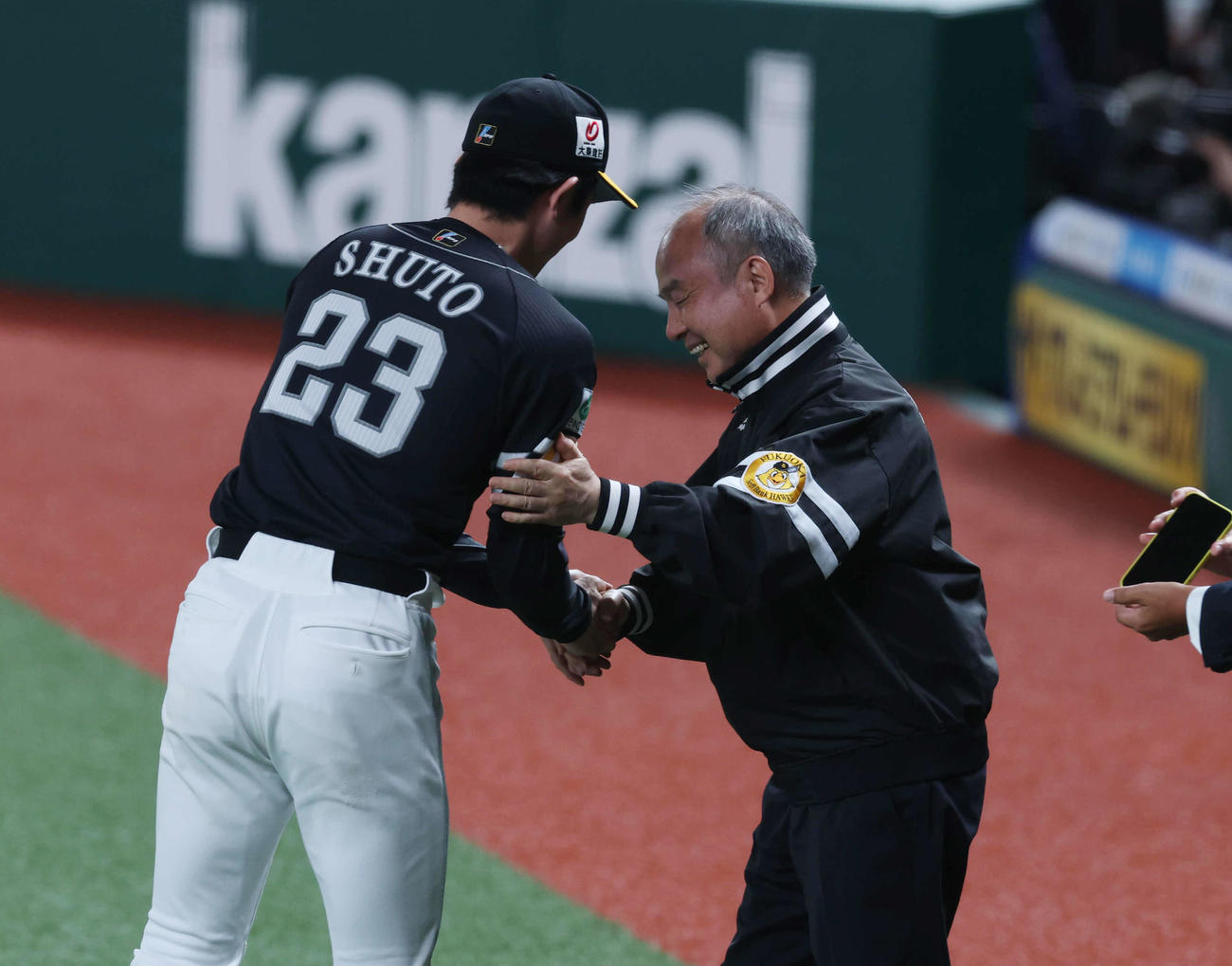 西武対ソフトバンク　優勝が決まり、握手を交わすソフトバンク孫オーナー（右）と周東（撮影・増田悦実）