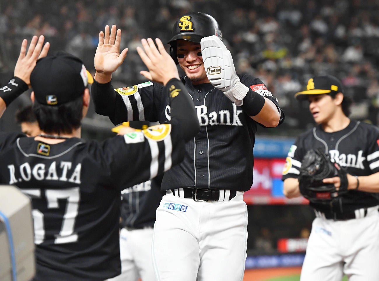 西武対ソフトバンク　5回表ソフトバンク1死一、三塁、柳町の右前適時打で生還した栗原（中央）は緒方（左）らナインと笑顔でタッチを交わす（撮影・岩下翔太）
