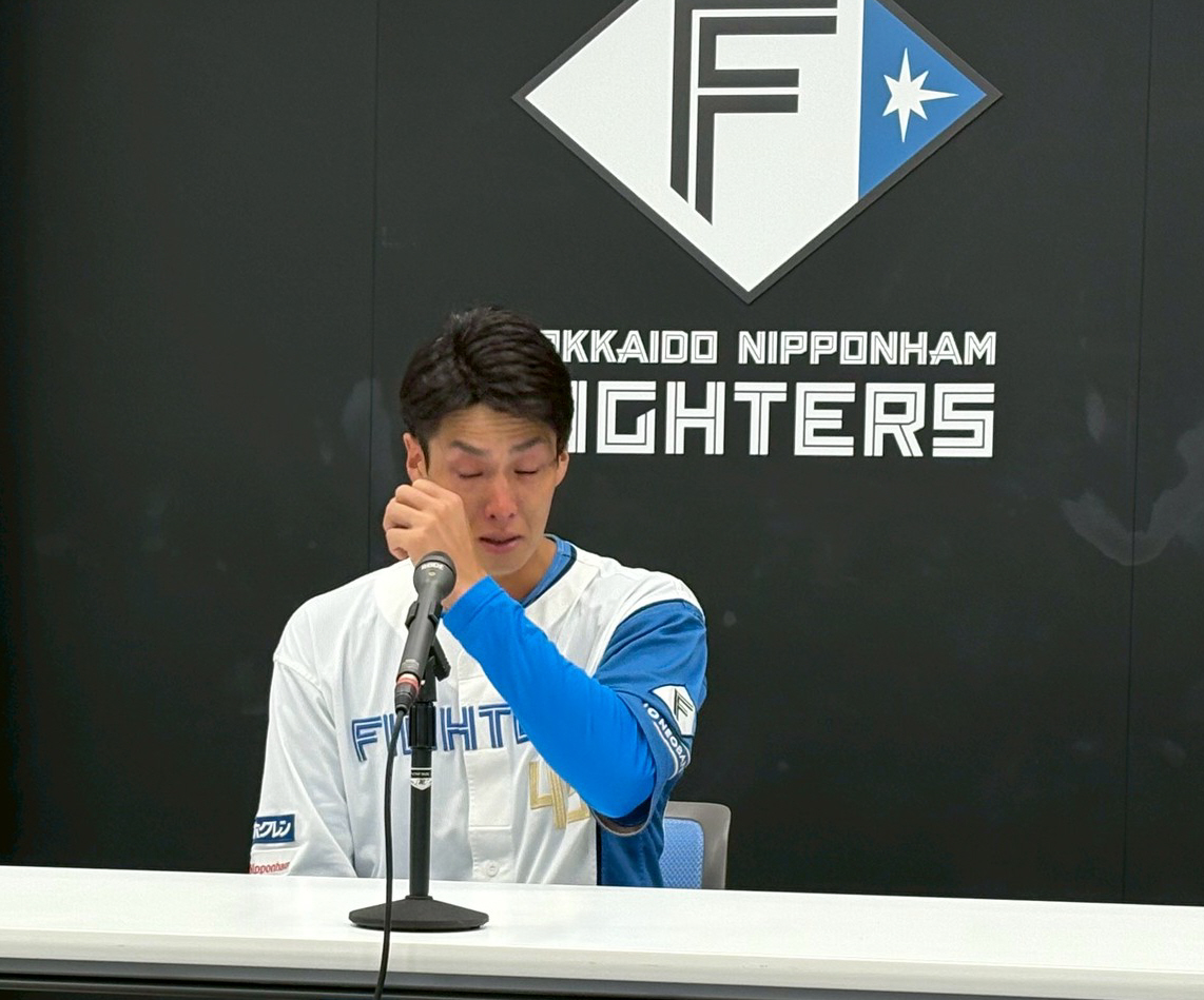 会見中に涙をぬぐう日本ハム若林