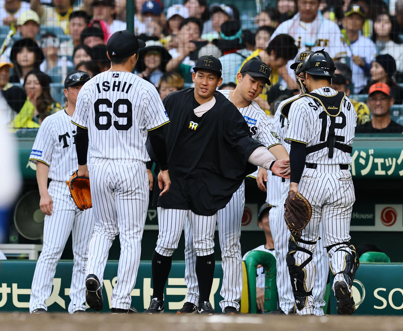 阪神対中日　8回を終え、石井らを出迎える阪神伊原（中央）（撮影・藤尾明華）