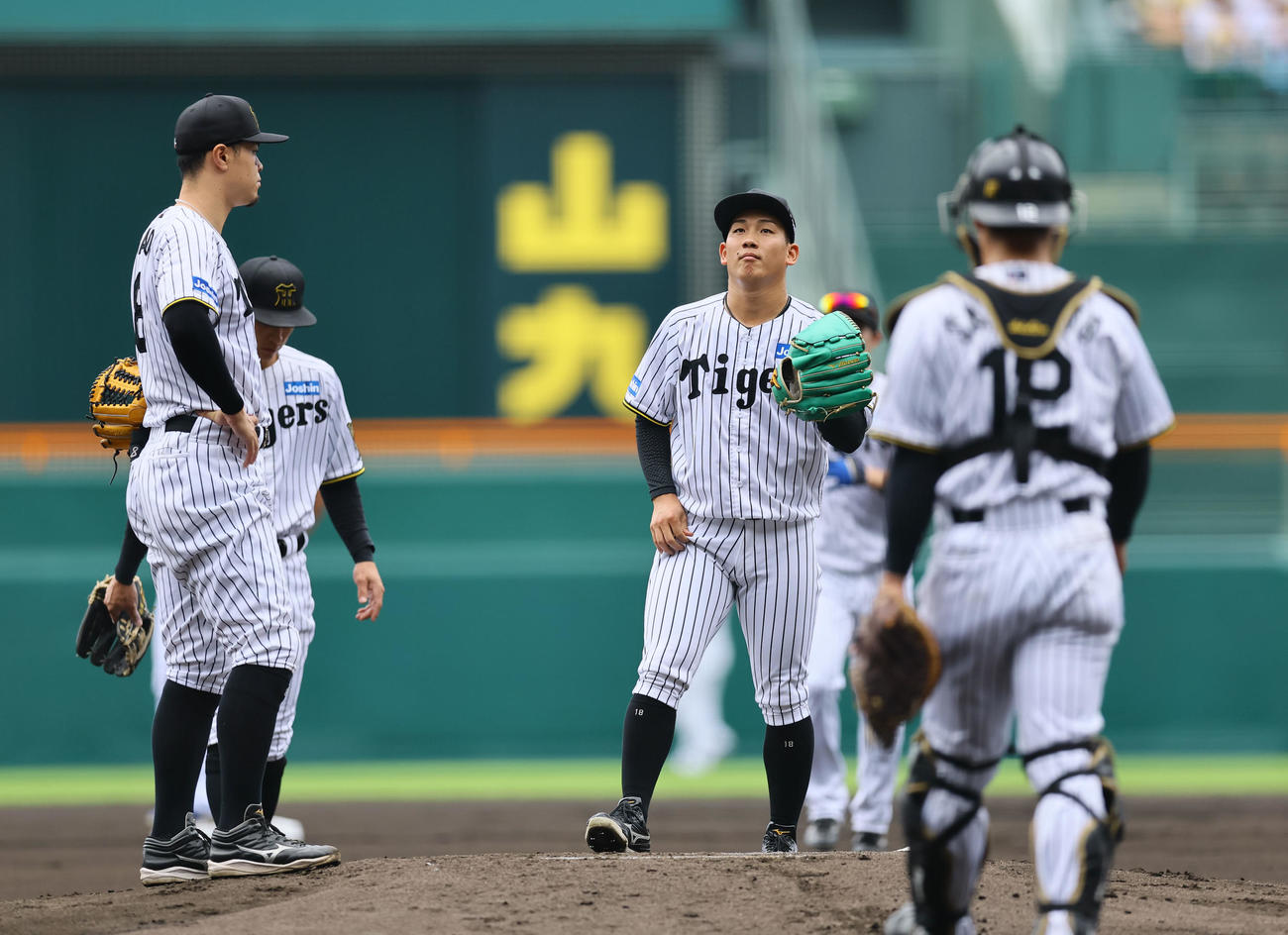 阪神対中日　1回、マウンドで声をかけられる阪神伊原（中央）（撮影・藤尾明華）