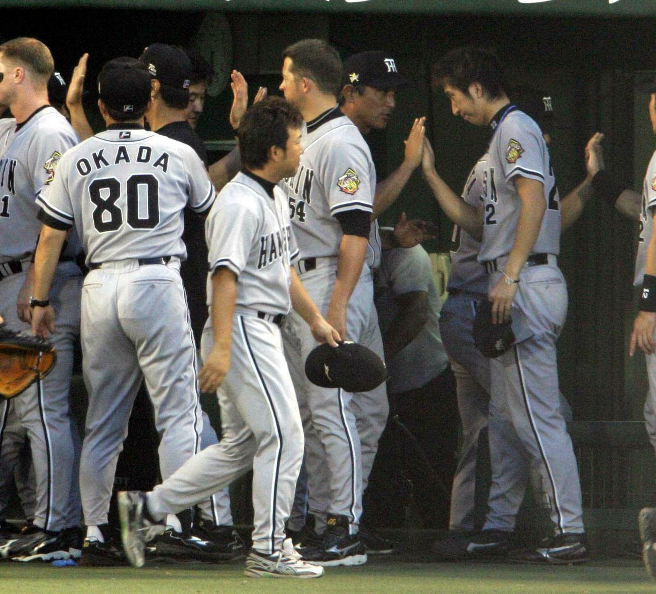 最多ホールドポイントを確定させた阪神藤川球児（右）は試合後、ナインとハイタッチ（2005年9月23日撮影）