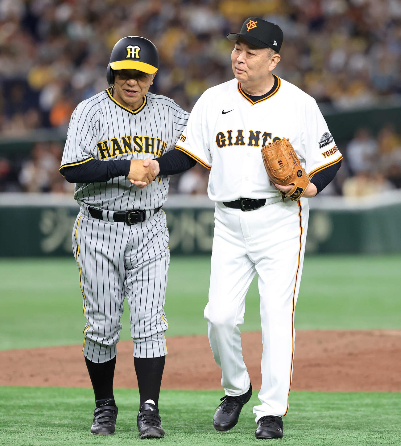 24年7月　巨人対阪神OB戦　2回表阪神無死、掛布雅之氏（左）は安打を放ち、江川卓氏と握手する