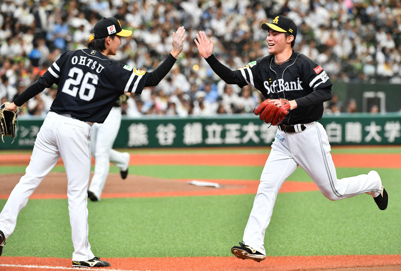 西武対ソフトバンク　1回裏西武2死、西川の遊ゴロを好守した庄子（右）とタッチを交わす大津（撮影・岩下翔太）