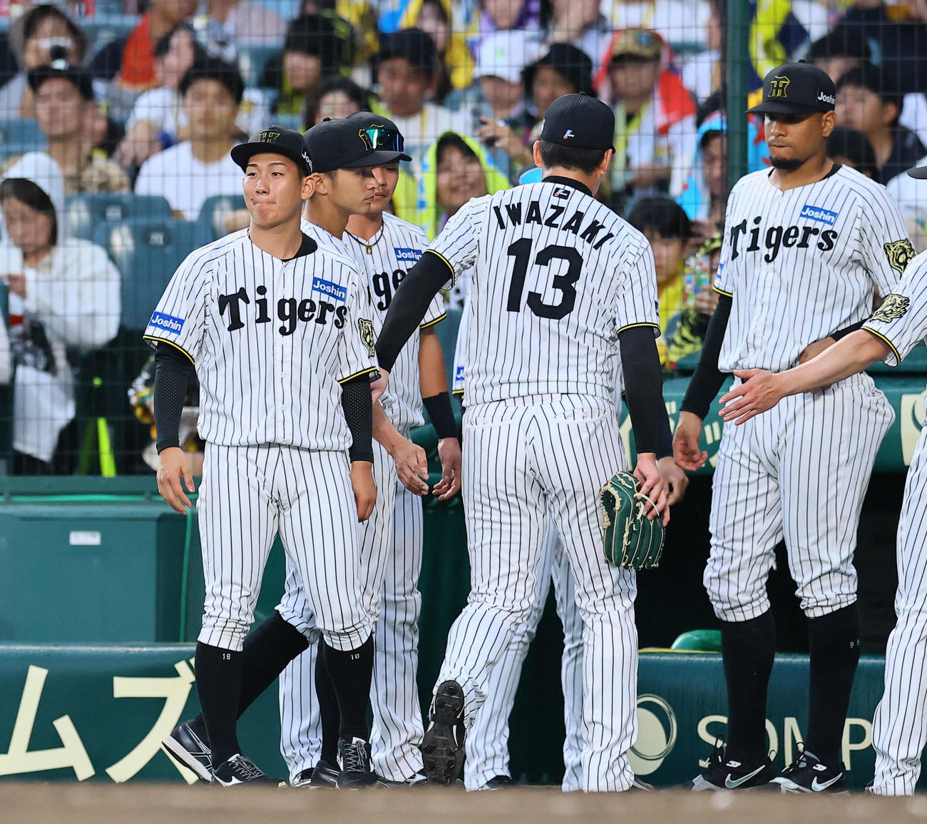 阪神対中日　9回途中、勝ち越しを許し降板し、伊原（左端）を労う阪神岩崎（撮影・藤尾明華）