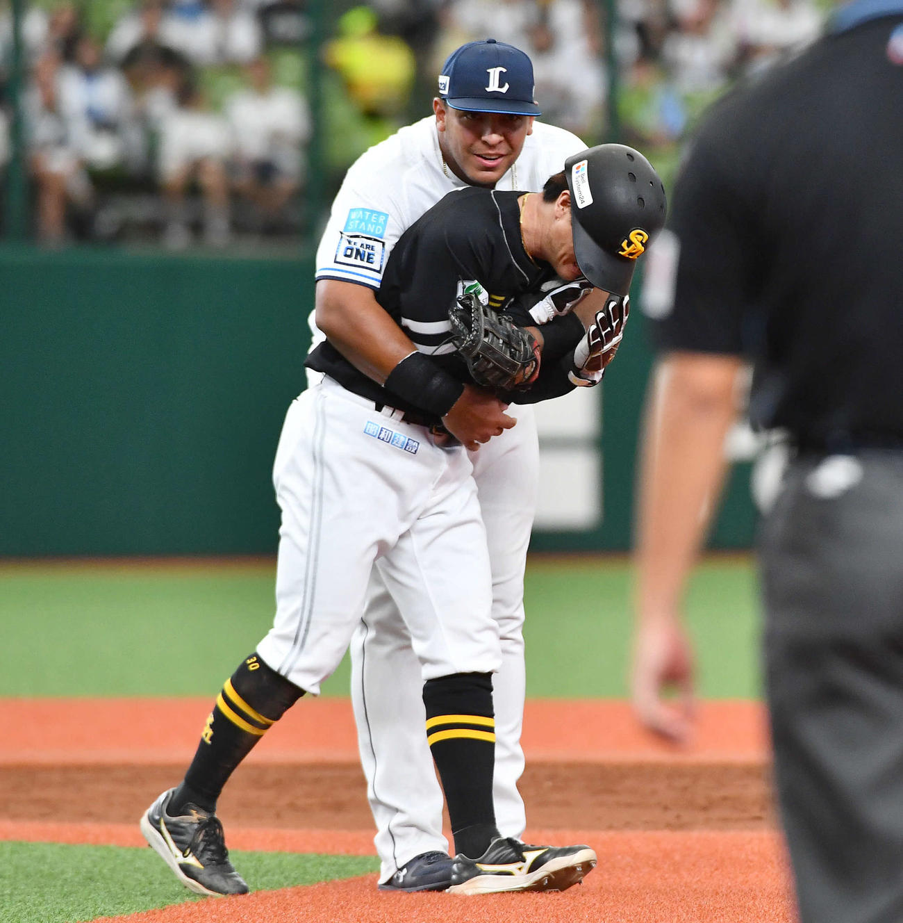 西武対ソフトバンク　5回表ソフトバンク無死一塁、けん制で飛び出した一塁走者の佐藤直（手前）をタッチアウトにし、抱きつくセデーニョ（撮影・岩下翔太）