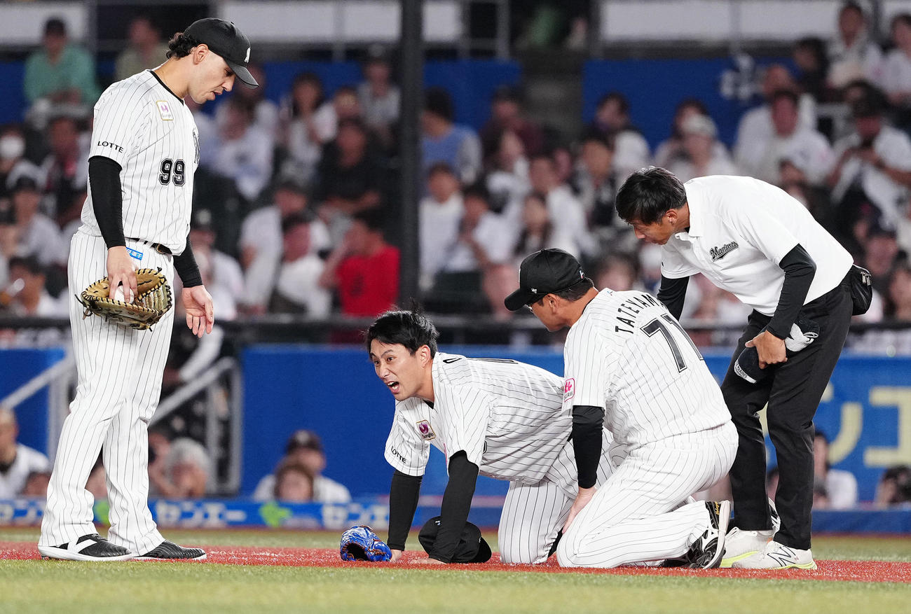 ロッテ対日本ハム　4回表日本ハム1死三塁、山県の打球を処理した後、痛がる小島（撮影・鈴木みどり）