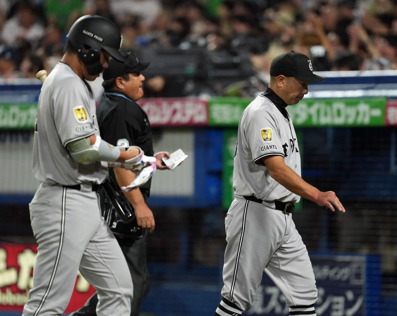 ヤクルト対巨人　10回裏、選手の交代を告げベンチに戻る阿部監督。左はチャンスで空振り三振に倒れた大城卓（撮影・たえ見朱実）