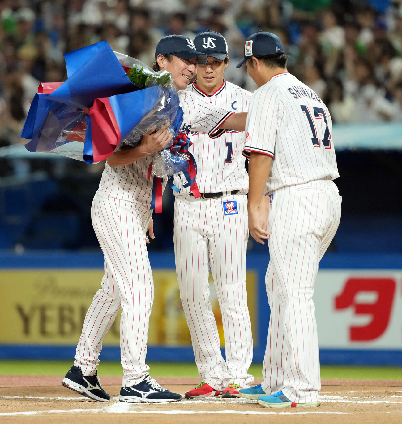 ヤクルト対巨人　今季で退任するヤクルト高津監督（左）は、花束を贈られ笑顔を見せる（撮影・たえ見朱実）