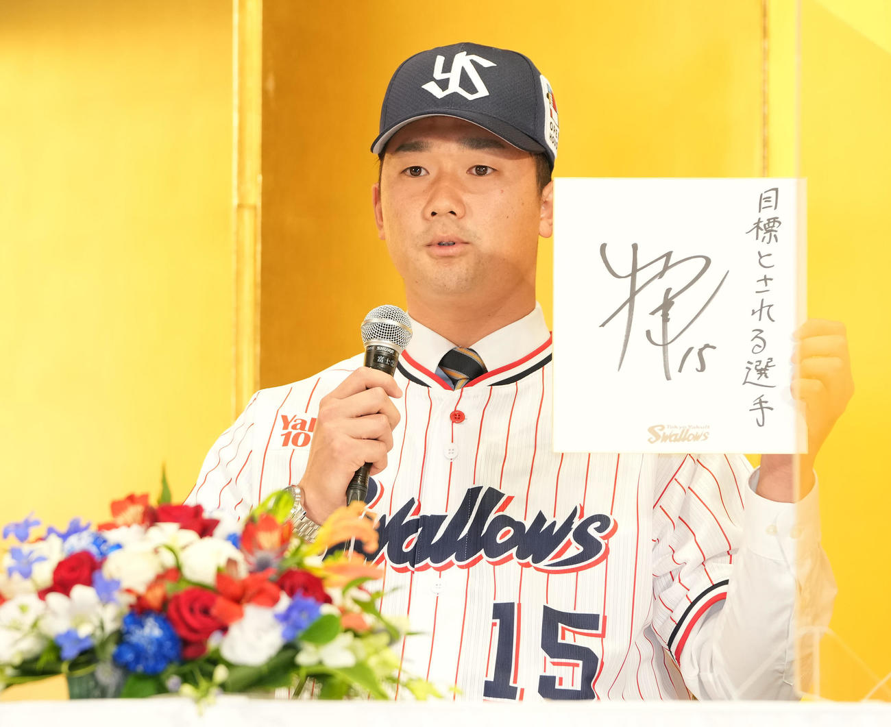 新入団選手発表会　目標をしたためた色紙を掲げるドラフト1位の法大・山下輝＝2021年12月10日