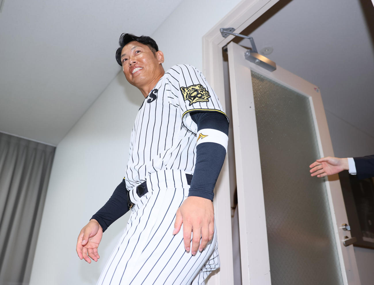 引退会見の席に向かう阪神原口（撮影・上山淳一）