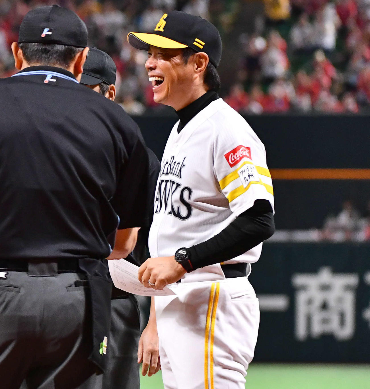 ソフトバンク対日本ハム　試合前、メンバー表交換で花束を手に登場した日本ハム新庄監督を見て笑顔を見せるソフトバンク小久保監督（撮影・岩下翔太）