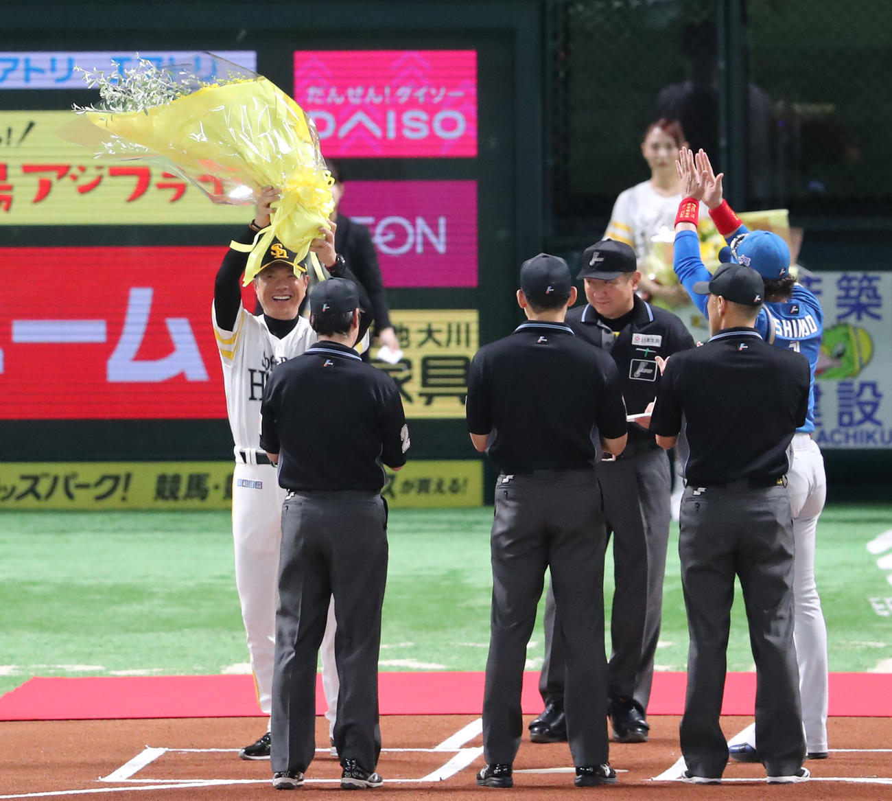 ソフトバンク対日本ハム　メンバー表交換のときに優勝のお祝いとして新庄監督から花束をプレゼントされた小久保監督は笑顔（撮影・梅根麻紀）
