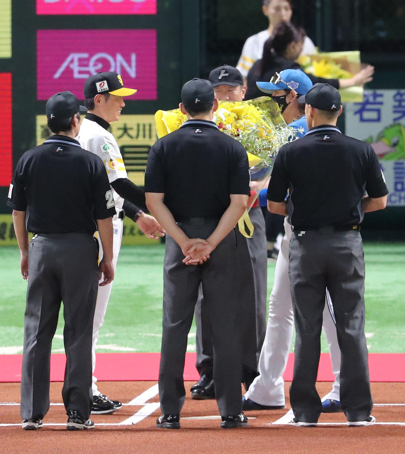 ソフトバンク対日本ハム　メンバー表交換のときに優勝のお祝いとして小久保監督に花束を渡す新庄監督（撮影・梅根麻紀）