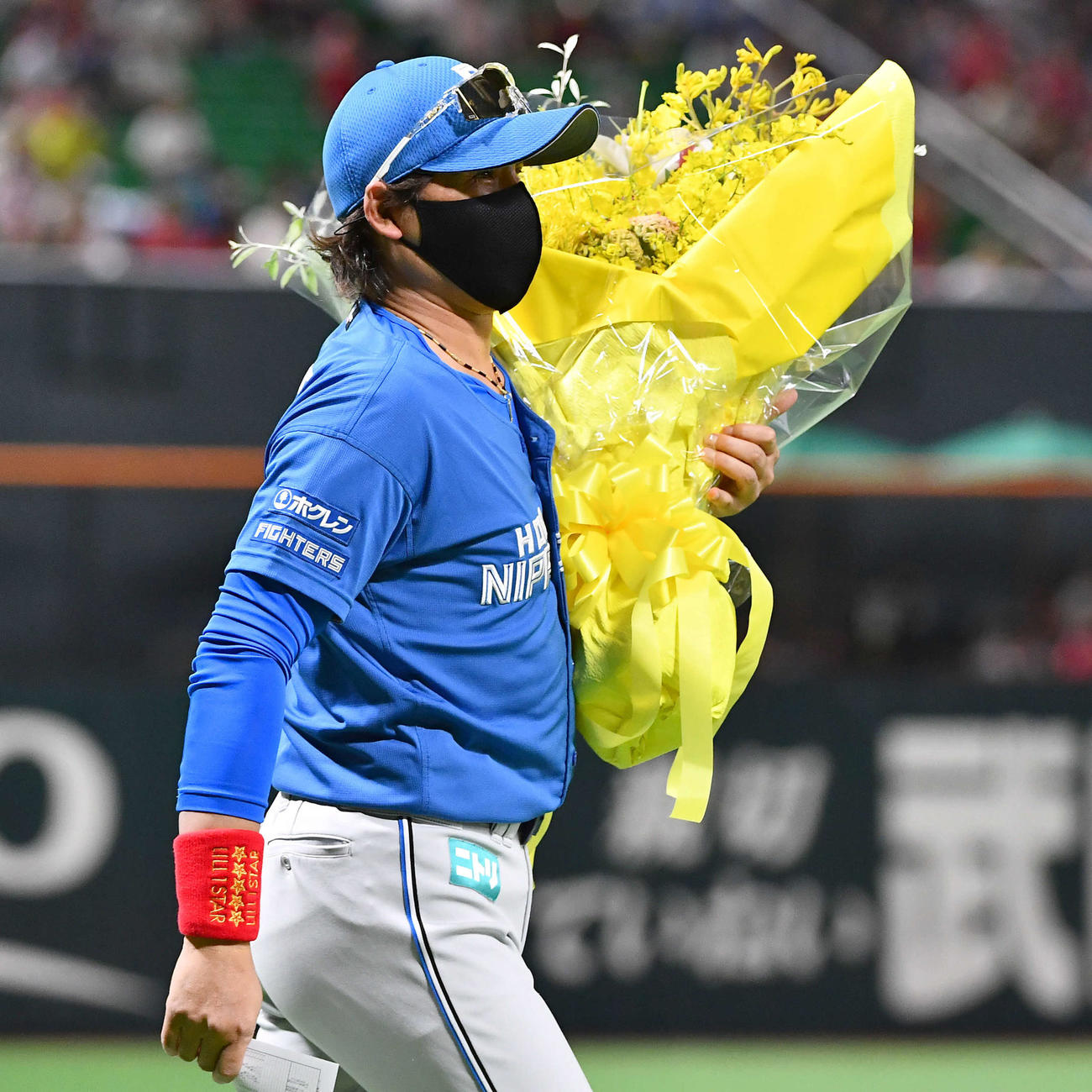 ソフトバンク対日本ハム　試合前、黄色の花束を手にメンバー表交換へ向かう日本ハム新庄監督（撮影・岩下翔太）
