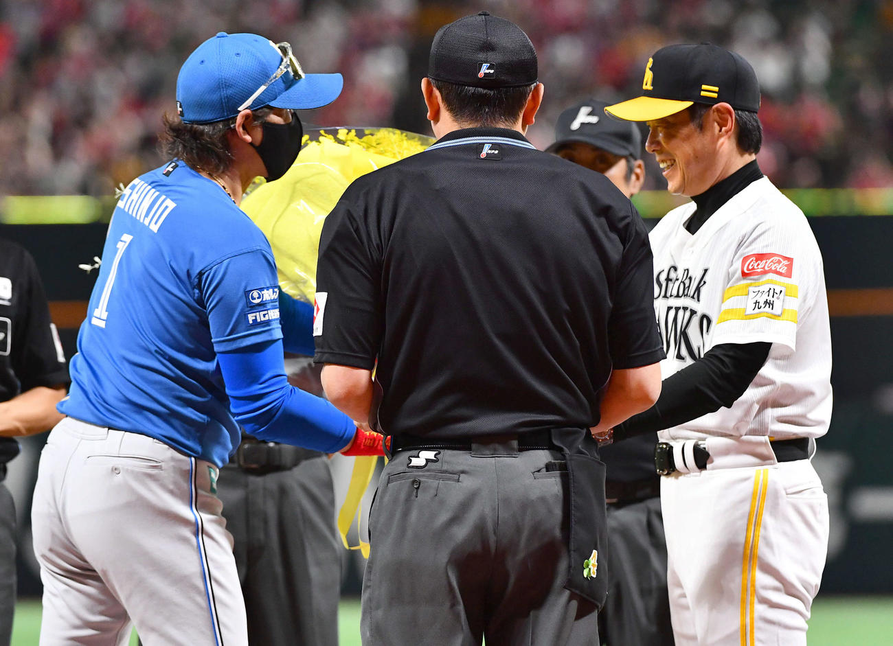 ソフトバンク対日本ハム　試合前のメンバー表交換でリーグ優勝したソフトバンク小久保監督（右）に黄色の花束をプレゼントする日本ハム新庄監督（撮影・岩下翔太）