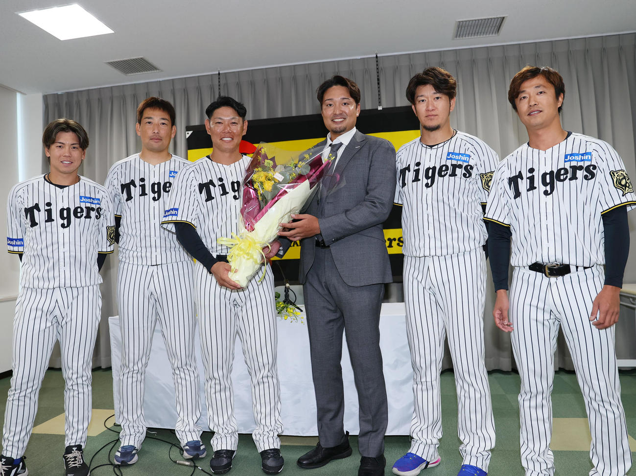 阪神原口（左から3人目）に花束を渡し、記念撮影する、左から梅野、岩崎、ひとりおいて秋山BA、岩貞、島本（撮影・上山淳一）