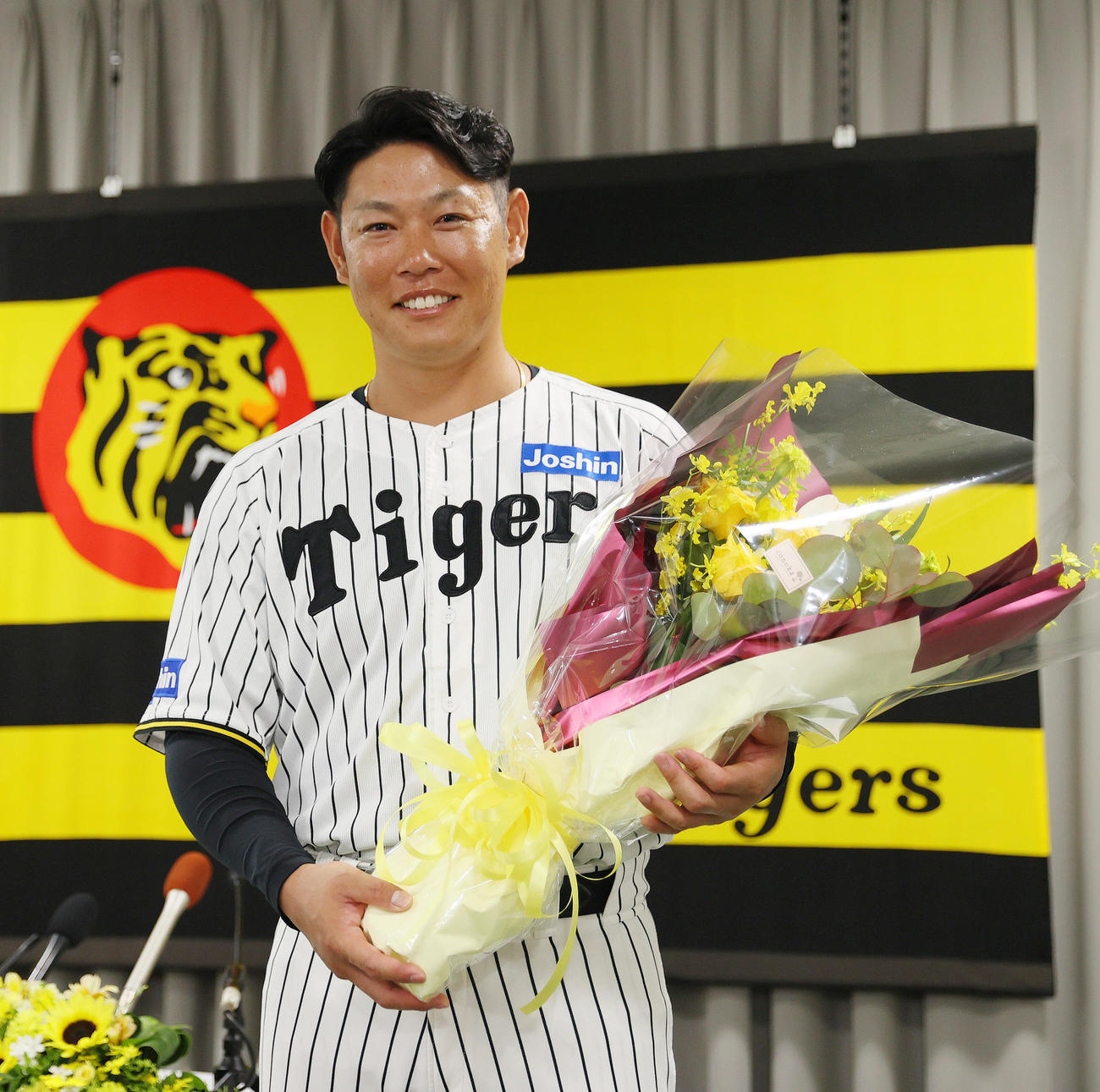 今季限りで現役を引退する阪神原口は花束を手に笑顔を見せる（撮影・上山淳一）