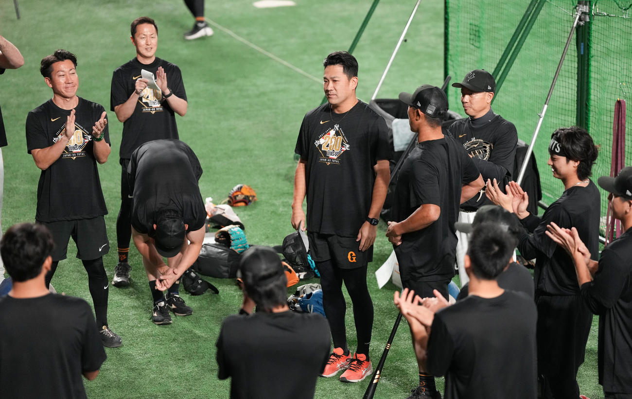 巨人対中日　試合前練習で日米通算200勝を投手陣に祝われる巨人田中将（中央）（撮影・鈴木みどり）
