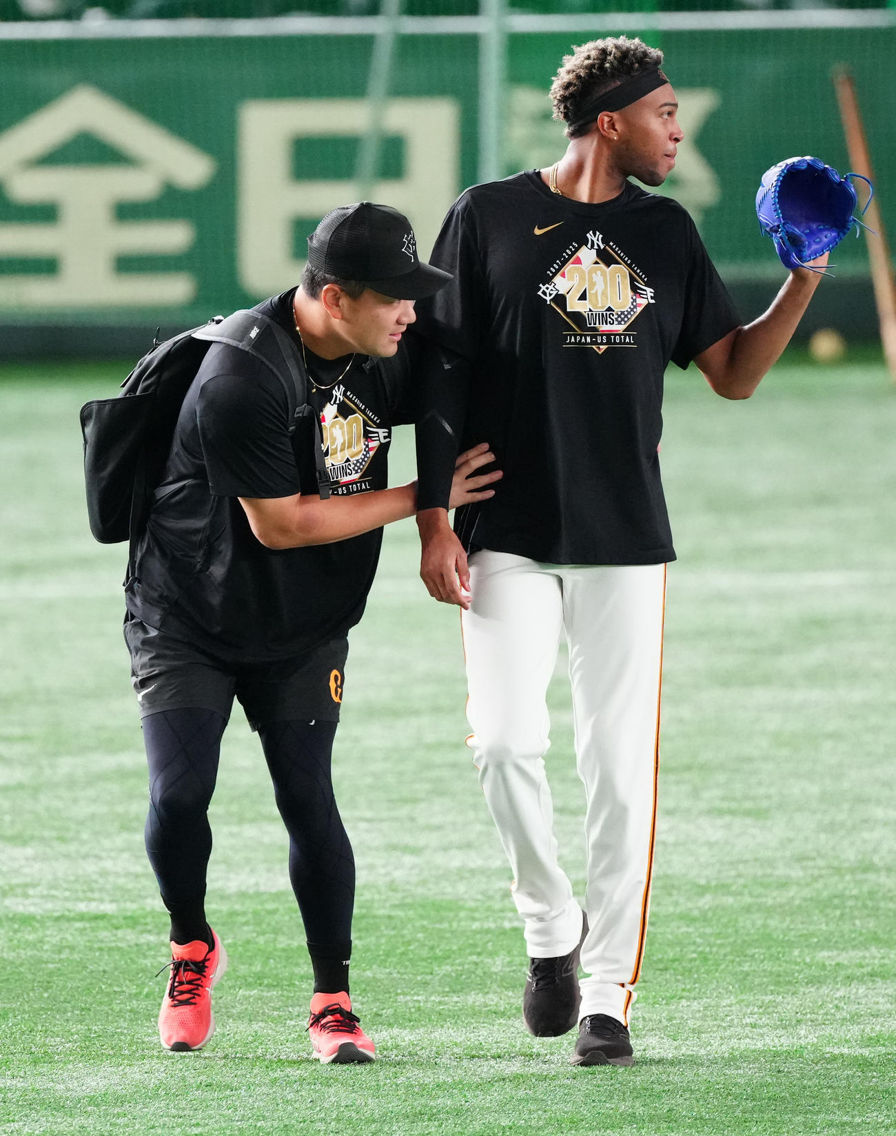 巨人対中日　マルティネス（右）の後ろに隠れながら試合前練習に向かう巨人田中将（撮影・鈴木みどり）