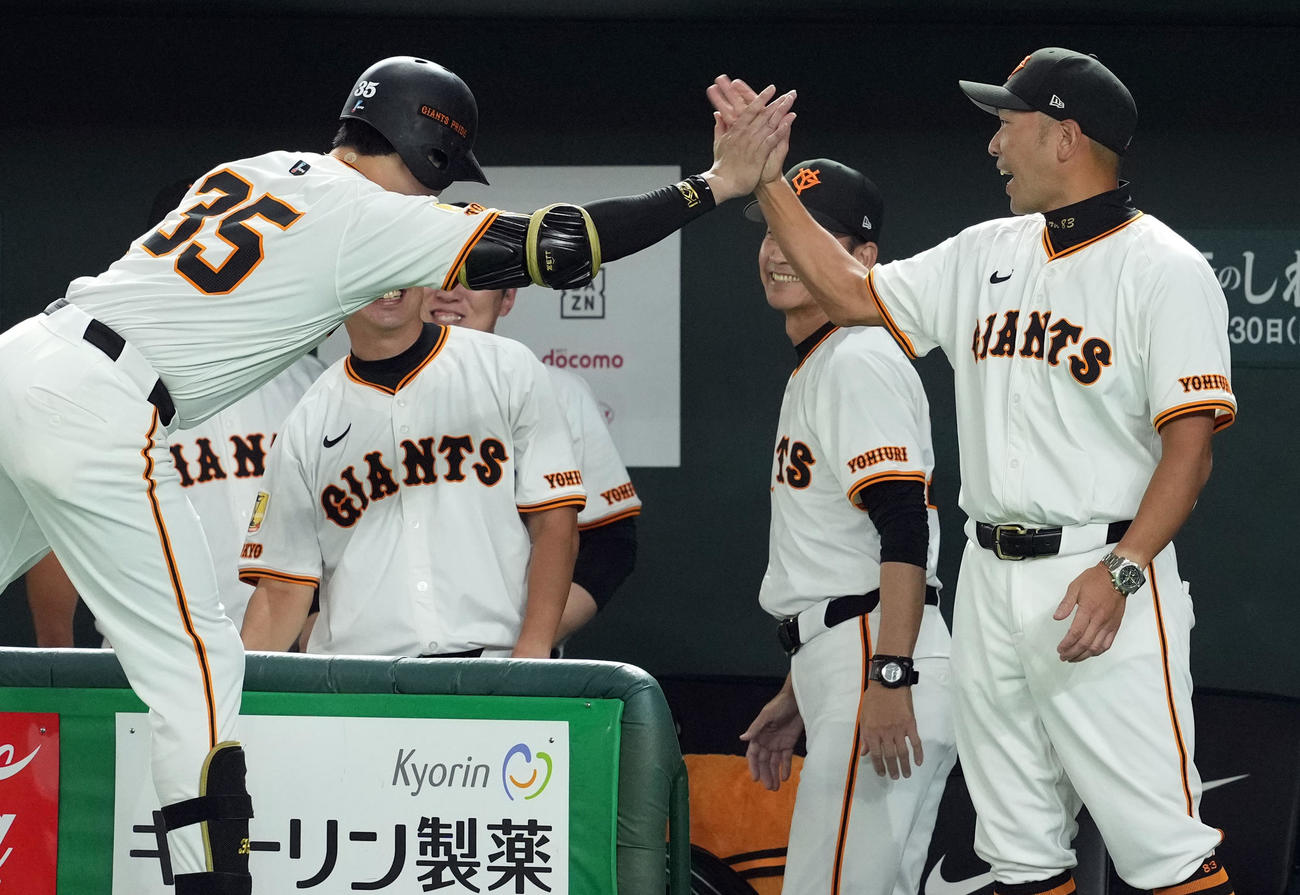 巨人対中日　6回裏巨人無死一塁、四球を選び出塁した泉口は、代走を出されベンチに戻り阿部監督とハイタッチを交わす（撮影・たえ見朱実）