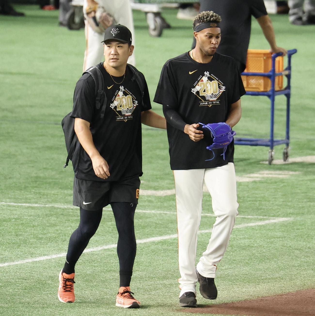 巨人対中日　試合前、巨人マルティネス(右)と寄り添いながらグラウンドに出る田中将(撮影・浅見桂子)