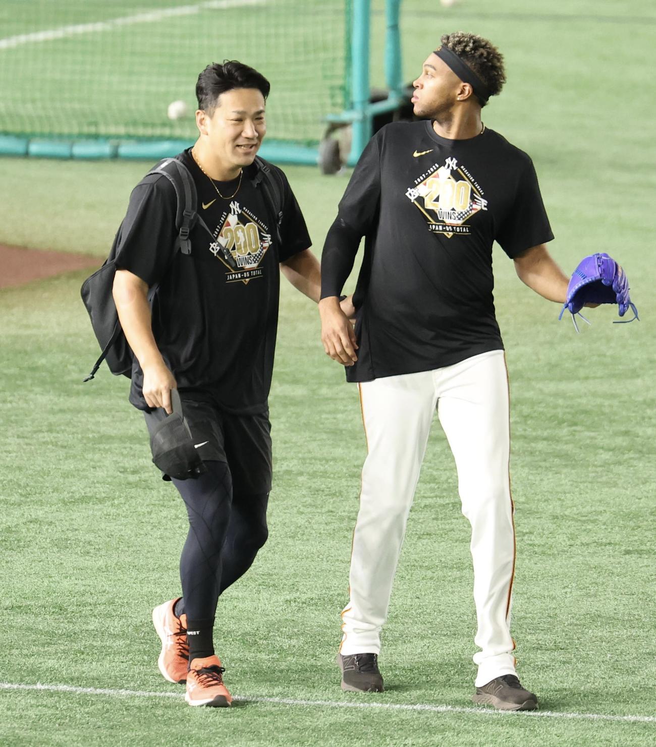 巨人対中日　試合前、巨人マルティネス(右)と寄り添いながらグラウンドに出る田中将(撮影・浅見桂子)
