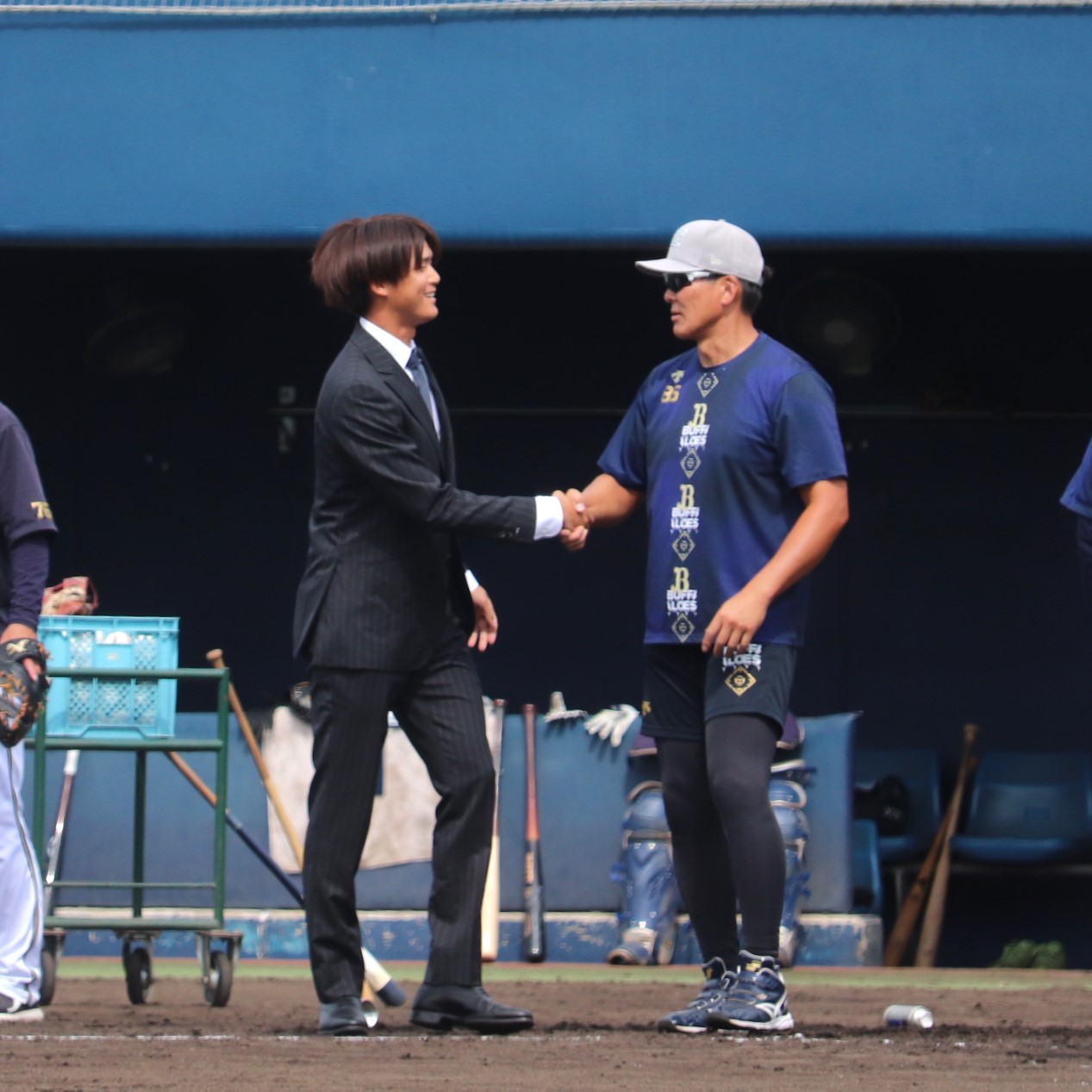 オリックス高橋信二コーチ（右）と握手を交わす佐野皓大外野手（撮影・中島麗）