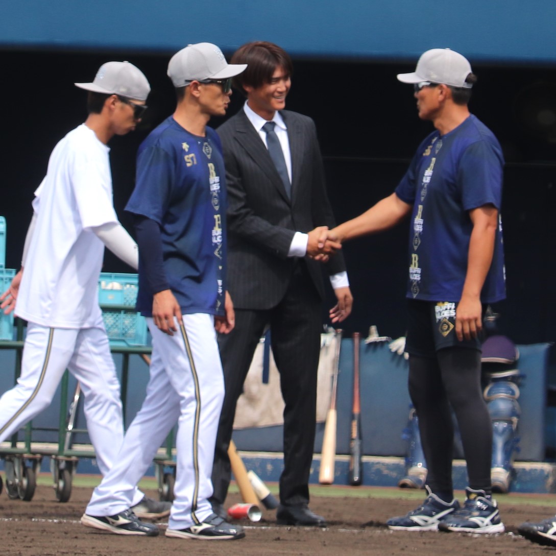 オリックス高橋信二コーチ（右）と握手を交わす佐野皓大外野手（撮影・中島麗）