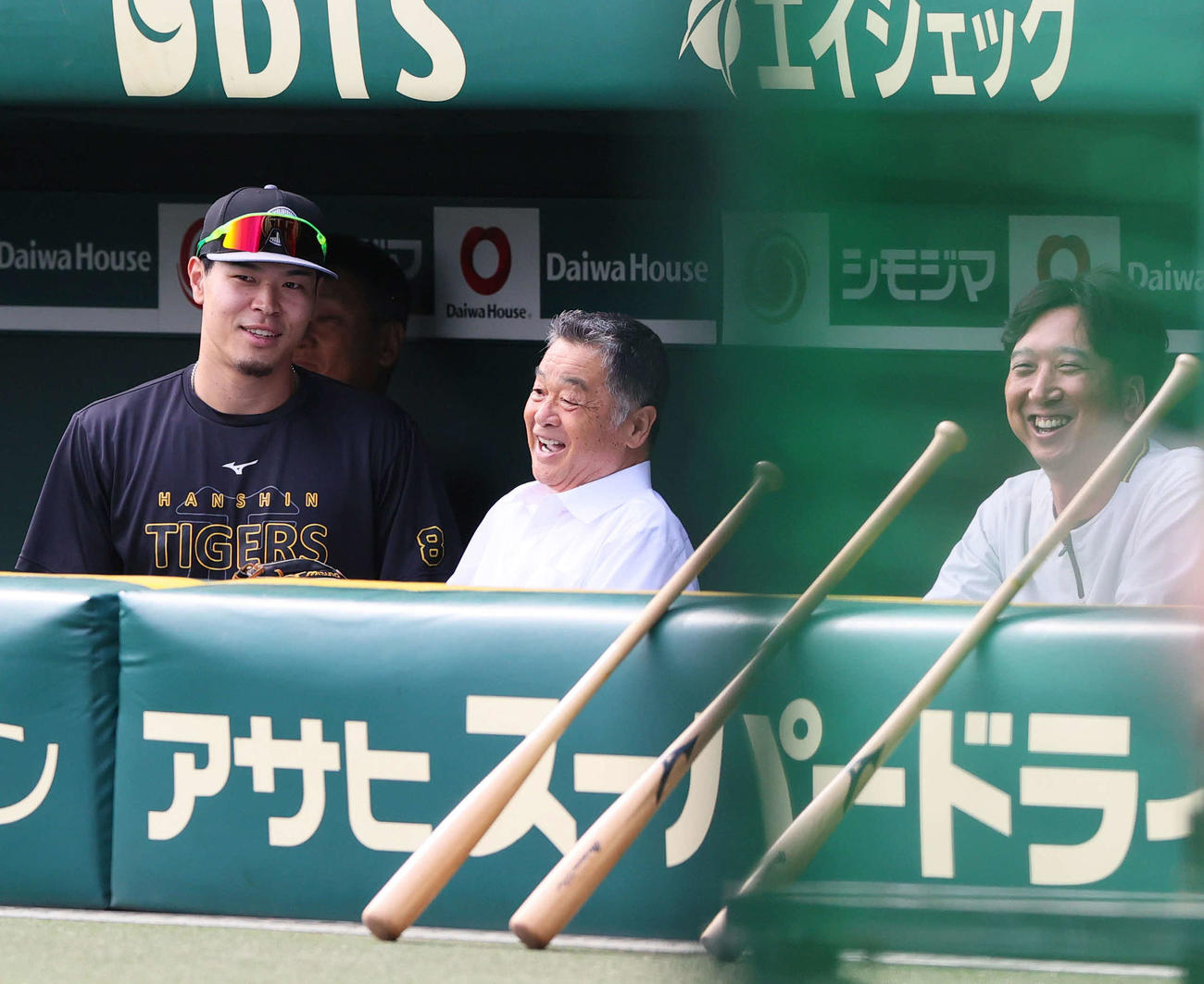 阪神対ヤクルト　試合前、阪神佐藤輝（左）はベンチでOBの川藤氏（中央）と藤川監督と談笑する（撮影・上山淳一）