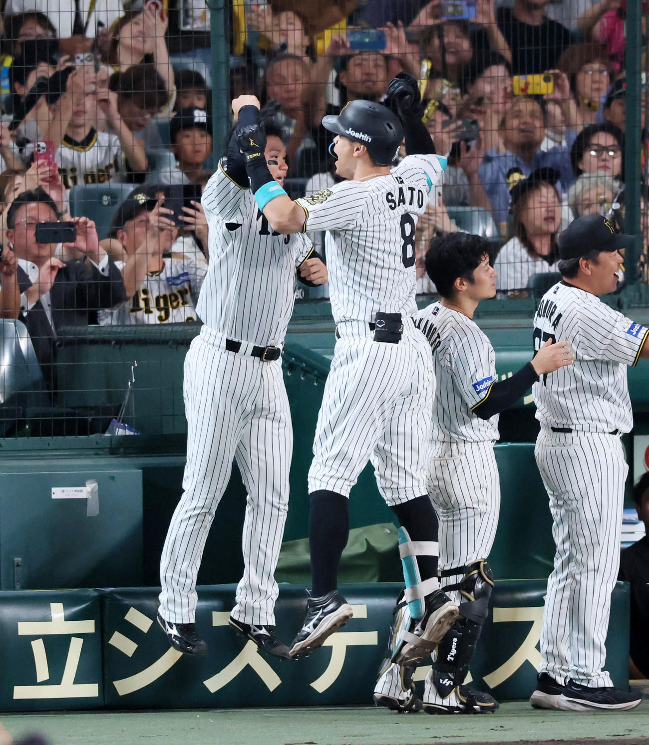阪神対ヤクルト　5回裏阪神1死二塁、佐藤輝は右越え2点本塁打を放ちベンチ前の森下（左）とジャンプしてタッチする（撮影・加藤哉）