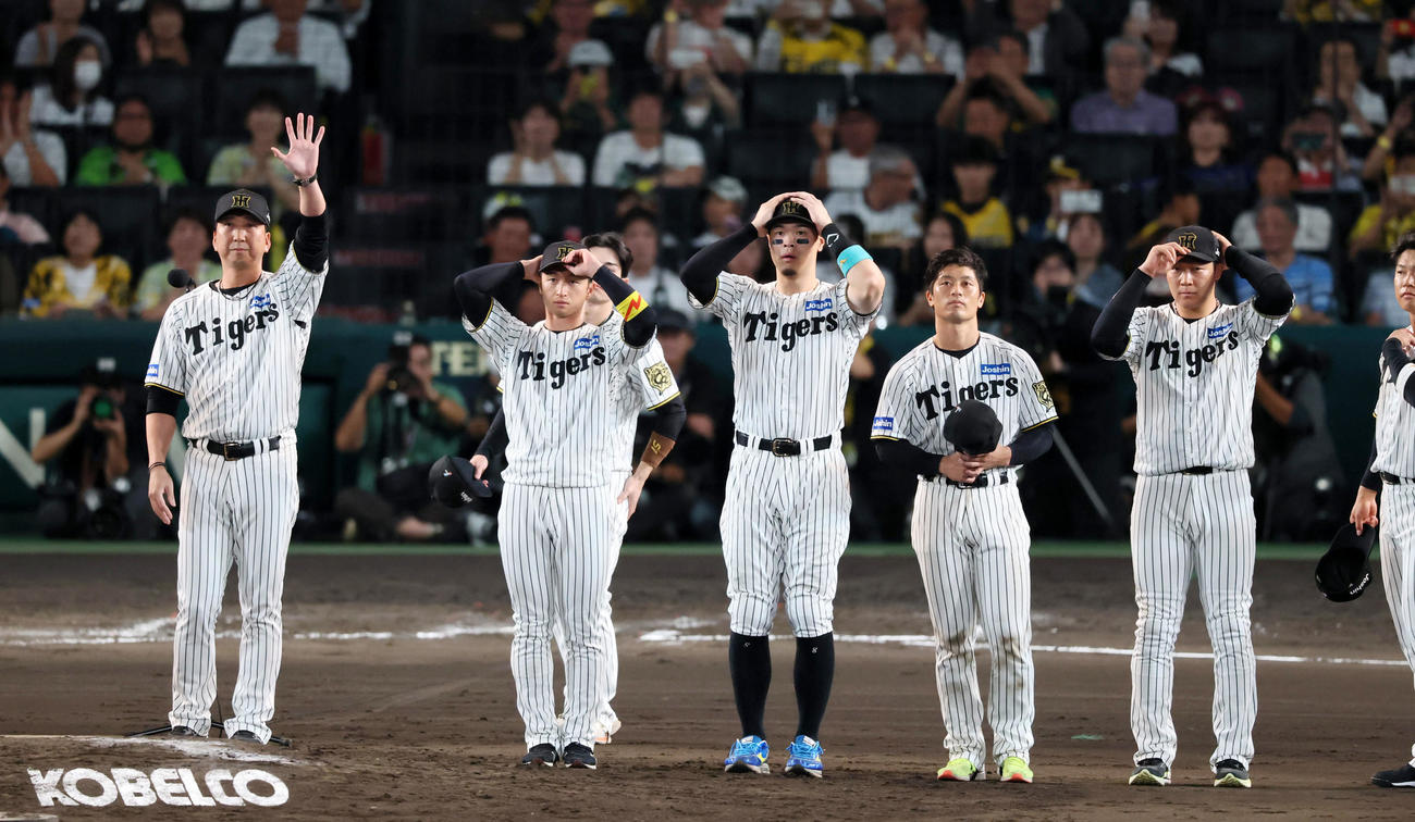 阪神対ヤクルト　今季最終戦を終えファンにメッセージを伝え手を振る藤川監督（左）とナイン（撮影・加藤哉）