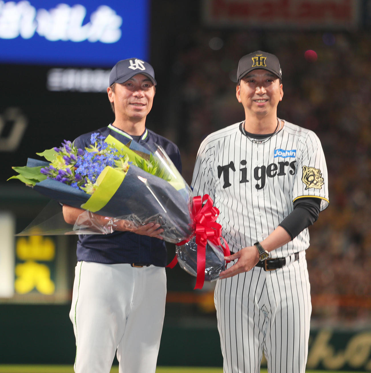 阪神対ヤクルト　今シーズン限りで退任するヤクルト高津監督（左）に花束を渡し記念撮影する阪神藤川監督（撮影・上山淳一）