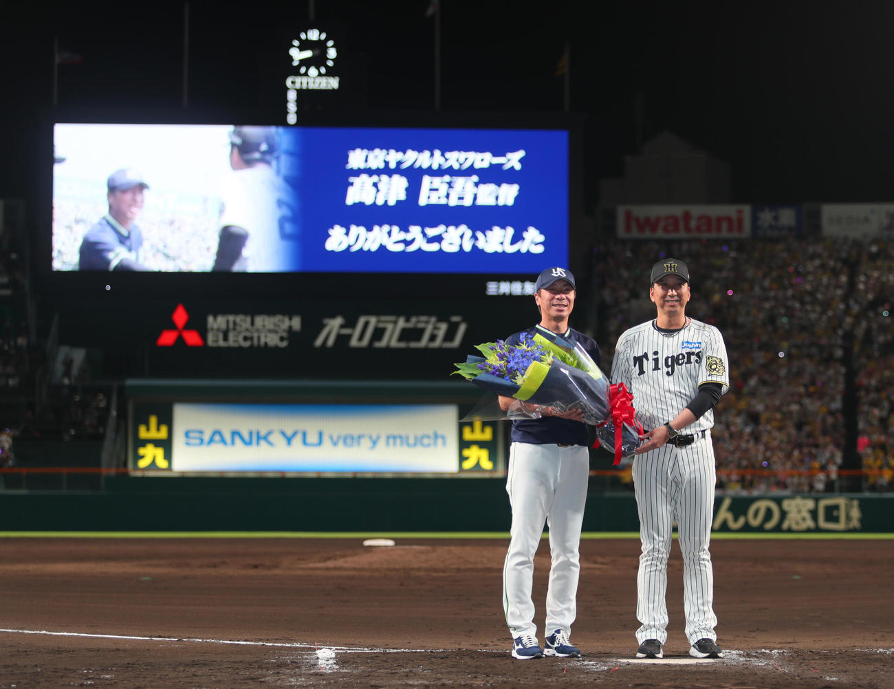 阪神対ヤクルト　今シーズン限りで退任するヤクルト高津監督（左）に花束を渡し記念撮影する阪神藤川監督（撮影・上山淳一）