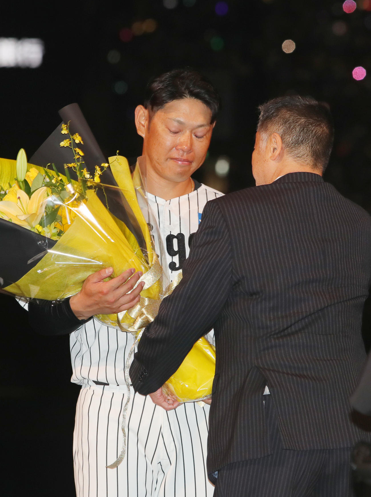引退セレモニーで阪神原口はOBの川藤氏から花束を受け取る（撮影・上山淳一）